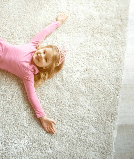 Cute girl laying on rug | Carpetland USA Granite & Flooring